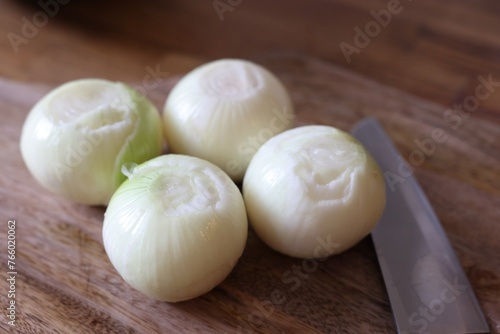 Fresh ripe onion bulbs on wooden table  closeup