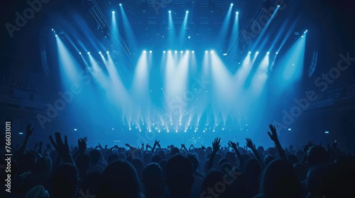 crowded concert hall with scene stage lights in blue tones, rock show performance, with people silhouette, on a dance floor air during a concert festival photo