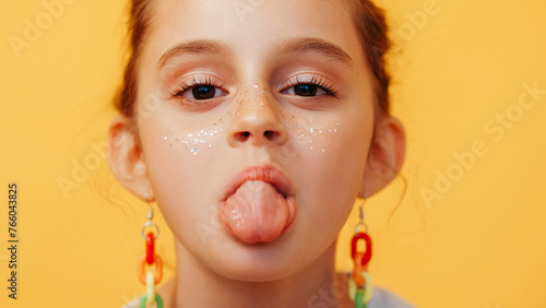фотографія Tongue out child grimacing kid playful little girl