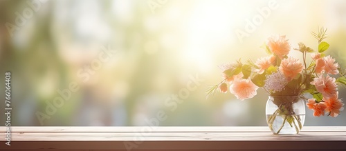 A beautiful vase filled with peach flowers is placed on a wood window sill, with the sky and grass outside creating a picturesque backdrop