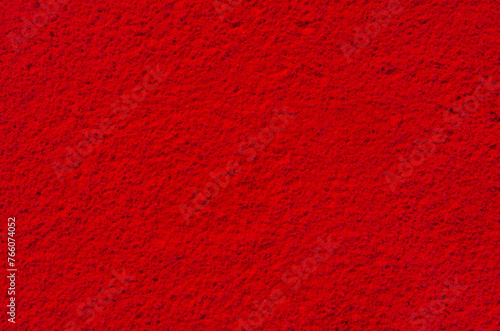 Brilliant red textured background. Backdrop with bright red abstract color. Texture and grain in blood red color.