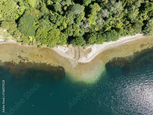 Aerial: Forest and calm waters of Lake Tarawera, Rotorua, Bay of Plenty, New Zealand.