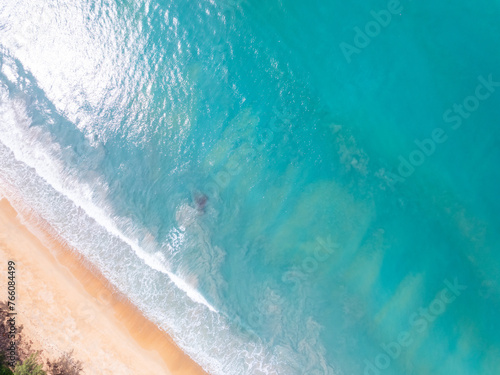 Top view beach with waves crashing on sandy shore,Beautiful waves sea surface in summer seascape background,Amazing beach colorful water background