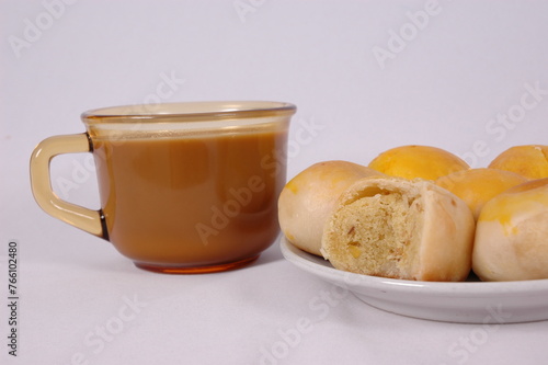 Tau Sar Piah with Sweet green been and Sweet black seeds and salted egg on a white background with a cup of hot milk tea photo