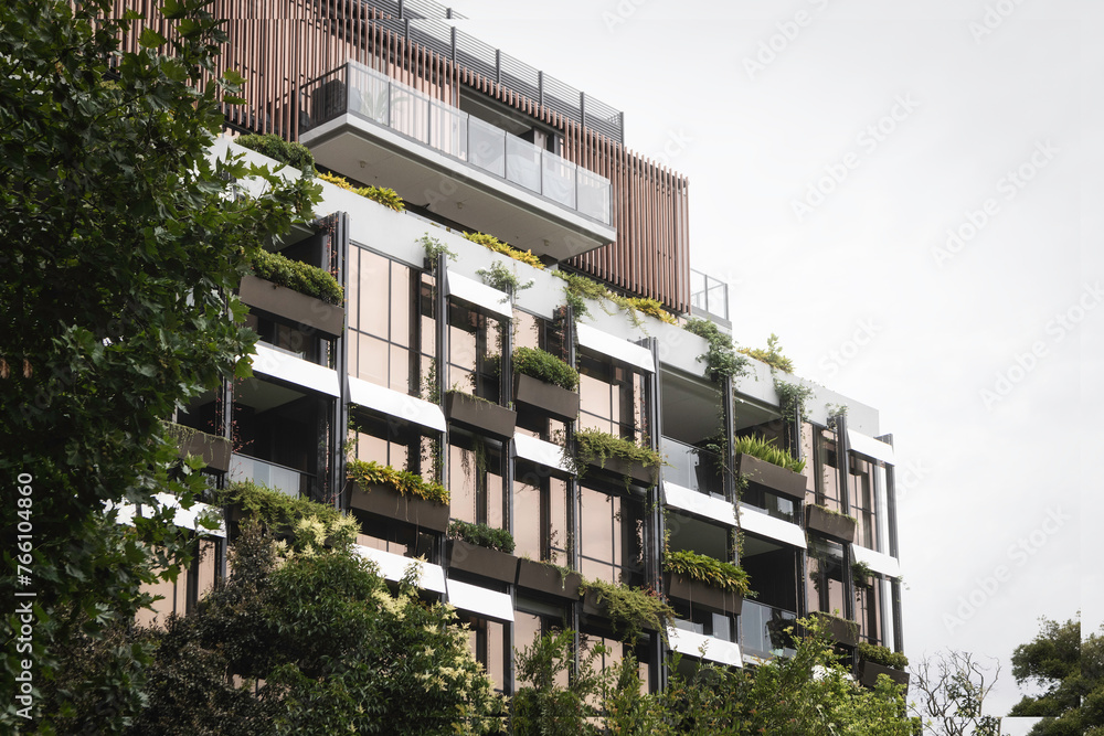 Obraz premium Clean, green energy urban building covered in plants and fauna. Ecological living in the city.