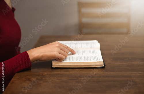 Close-up of a Christian woman's hands while reading the Bible in her room.