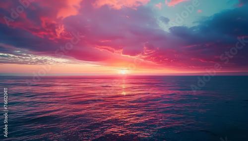 A beautiful sunset over the ocean with a few clouds in the sky
