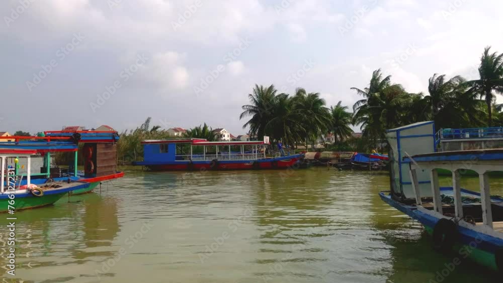 Tourist boats on a calm river. Boats on the Thu Bon River with palm trees in the background. Hoi An ancient town. UNESCO World Heritage site. Hoi An, Vietnam. Tourist boats on a calm river. Boats on the Thu Bon River with palm trees in the background. Hoi An ancient town. UNESCO World Heritage site. Hoi An, Vietnam.