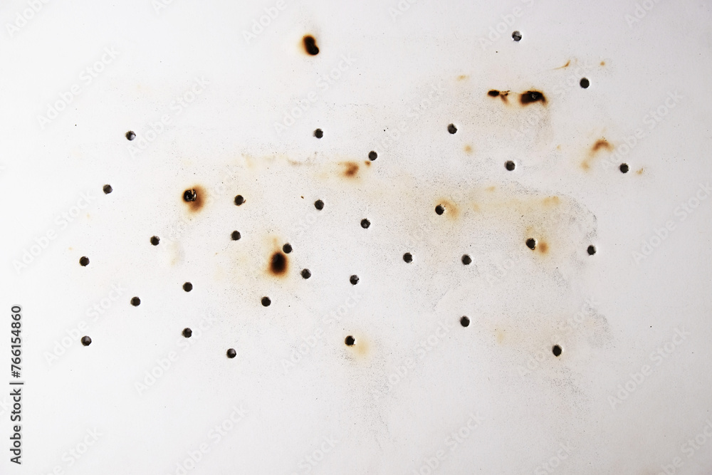 Bullet damage on white foam board, background with through holes. Bullet damage on white foam board, background with through holes.