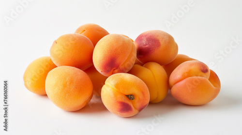 A cluster of ripe, golden apricots positioned elegantly on a clean white backdrop, showcasing their smooth skin and delicate blush.