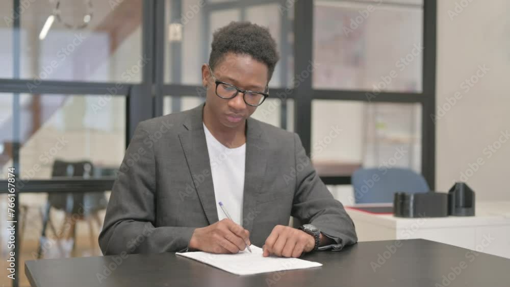 African American Man Working on Documents in Office African American Man Working on Documents in Office