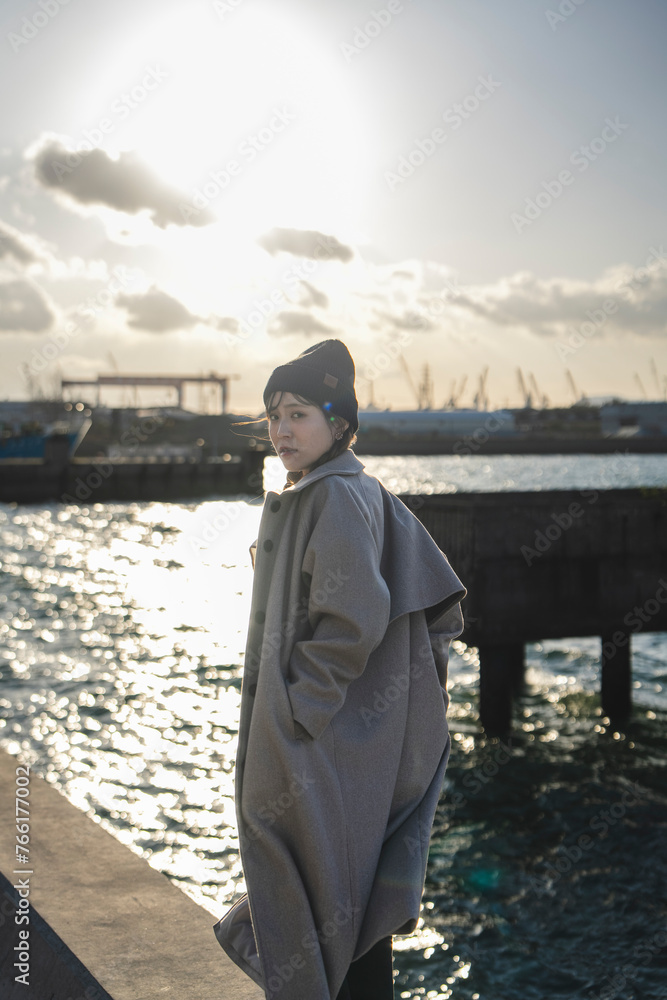 夕暮れの海を旅する女性