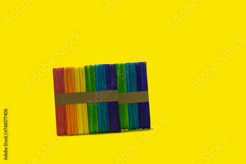 colorful popsicle sticks on a bright yellow background Ready to work on ideas © Kingkarn