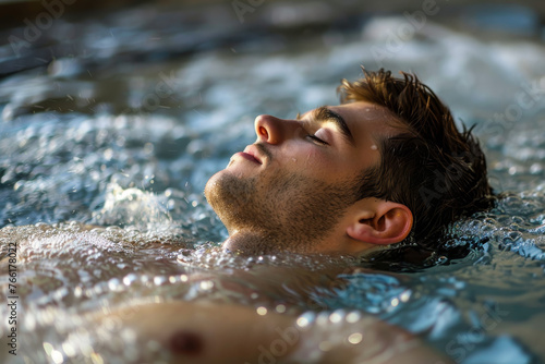 A handsome man enjoying a peaceful moment in a jacuzzi at a spa.