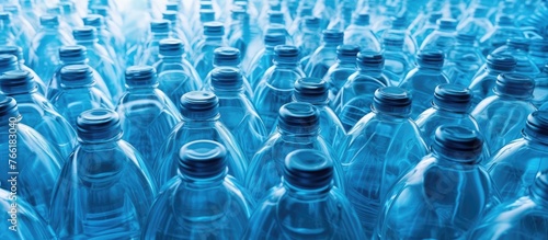 Several azure plastic water bottles are neatly arranged in a line, ready to be filled with refreshing aqua liquid