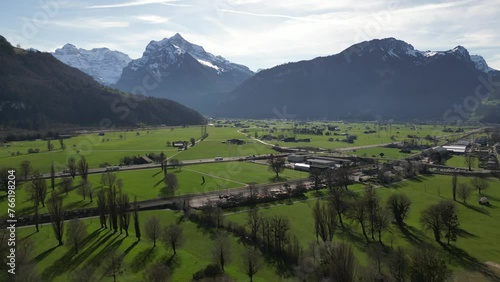 A captivating aerial view captures Weesen, a charming village nestled in See-Gaster, Canton of St. Gallen, Switzerland. Traffic flows along the highway, weaving through the valley amidst houses.