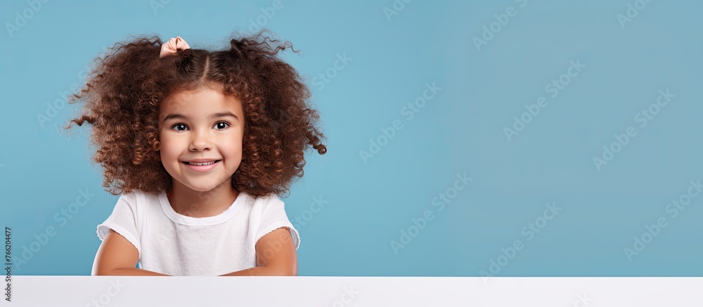 Young female child with curly hair, gripping a placard, displaying a message or drawing for an event or protest - obrazy, fototapety, plakaty 