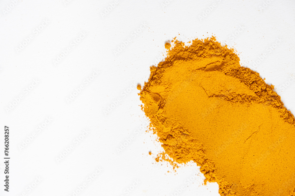 A smear of turmeric on a white background, top view A smear of turmeric on a white background, top view