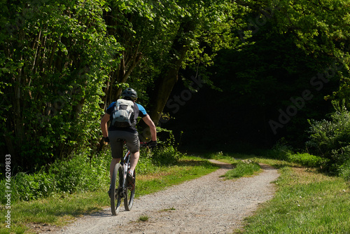 Mit dem Mountainbike unterwegs auf dem Kerkerbach-Radweg durch den frühlingshaften Wald