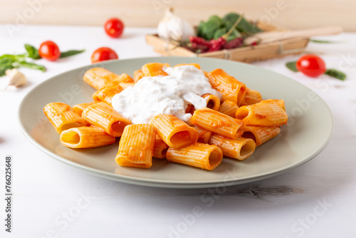 Macaroni with tomato sauce and stracciatella. Good and balanced Italian cuisine dish