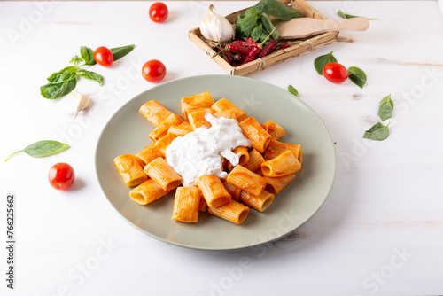Macaroni with tomato sauce and stracciatella. Good and balanced Italian cuisine dish
