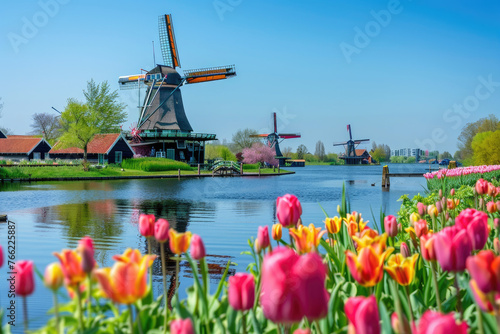 A picturesque scene of the windmills at a stadium in spring, surrounded by colorful tulips and lush greenery under clear blue skies