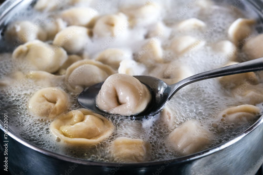 Dumplings are boiled in a pot of boiling water. Close-up. Dumplings are boiled in a pot of boiling water. Close-up.