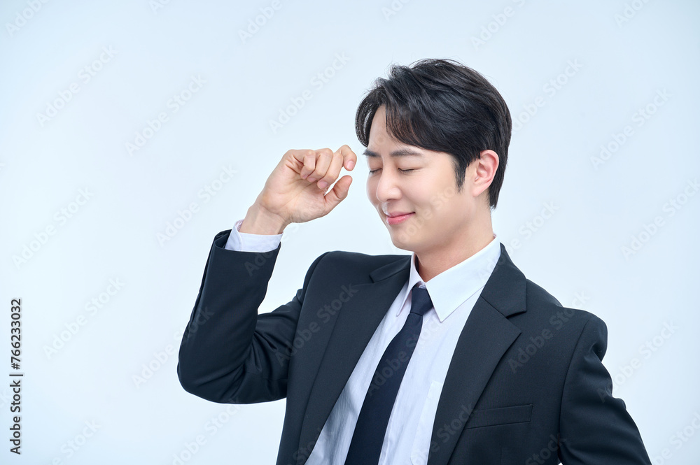 A young office worker man in a navy suit is posing with various facial expressions. A young office worker man in a navy suit is posing with various facial expressions.