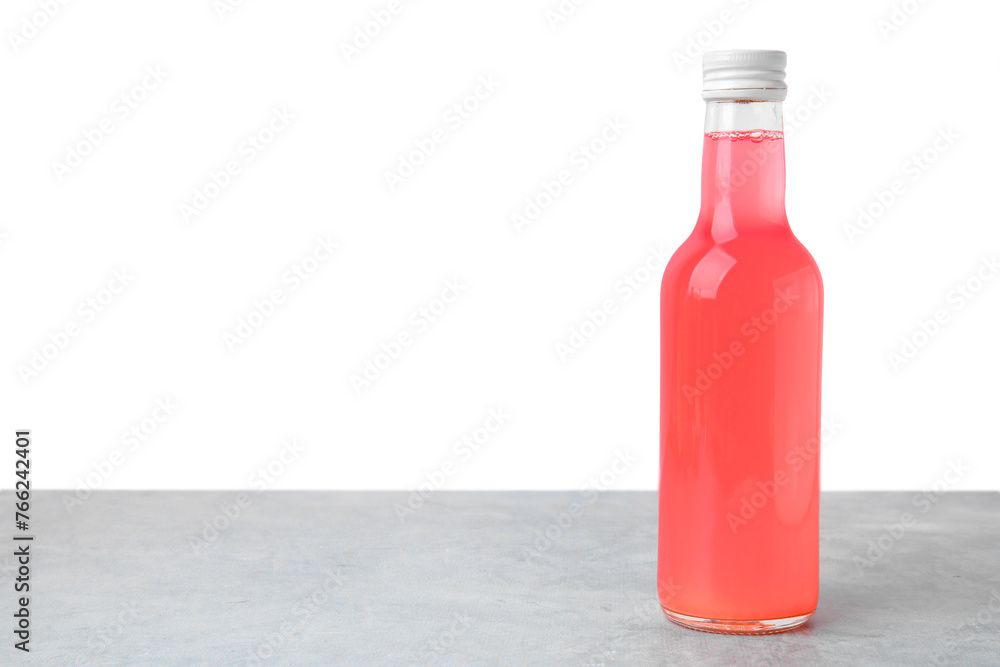 Delicious kombucha in glass bottle on grey table against white background, space for text Delicious kombucha in glass bottle on grey table against white background, space for text