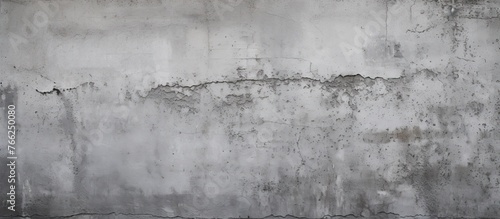 A detailed shot of a weathered gray concrete wall with peeling paint, showcasing a monochrome pattern resembling a composite material