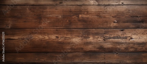 A close up of a hardwood wall with a brown wood stain in an amber hue. The rectangular planks create a beige flooring with a blurred background