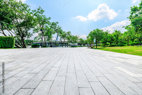 Empty square floor and trees with buildings in park