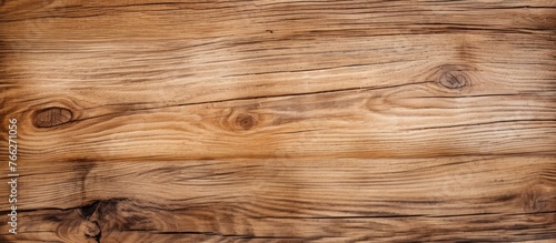 A closeup of a brown hardwood plank with knots and grain in a rectangle pattern, showcasing its amber and beige wood stain on the surface
