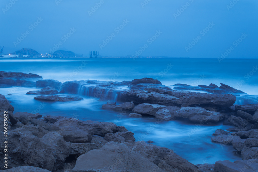 Larga exposición de paisaje maritimo en día de levante sobre la costa blanca, playa de Agua amarga de Alicante, España Larga exposición de paisaje maritimo en día de levante sobre la costa blanca, playa de Agua amarga de Alicante, España