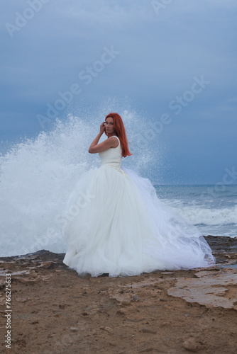 Mujer con traje de novia empoderada deja a su novio en el altar y se marcha a la playa, Alicante, España photo