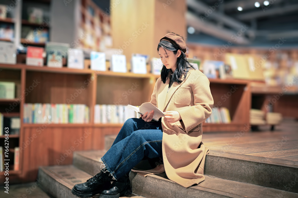 Young Woman Engrossed in Reading at Cozy Bookstore Young Woman Engrossed in Reading at Cozy Bookstore