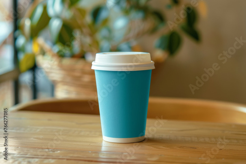 A teal coffee cup on a wooden table, exuding modern eco-friendly vibes.