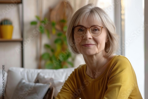 Warm smiling woman with glasses in a cozy home setting.