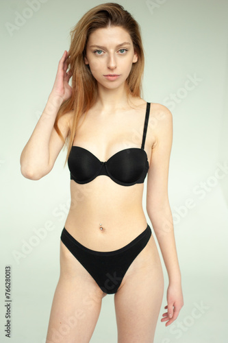 Snap Models. Full length portrait of a beautiful brunette woman in black bikini isolated on white background © alipko