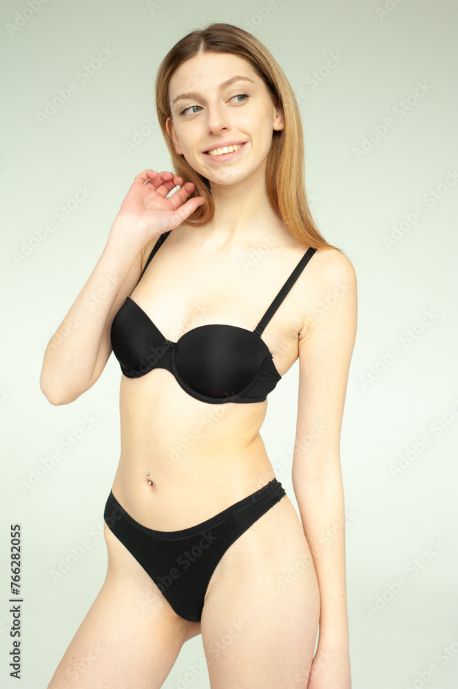 Fototapeta premium Model test portrait with young beautiful fashion model posing on grey background.