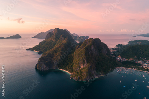 Aerial view of cliffs in the sea, yachts are sailing nearby, mountains covered with tropical forest. El Nido, Palawan, Philippines. © Евгений Бахчев