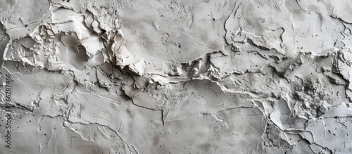 An image showing a detailed view of a white wall where the paint is peeling off, revealing the bare surface underneath
