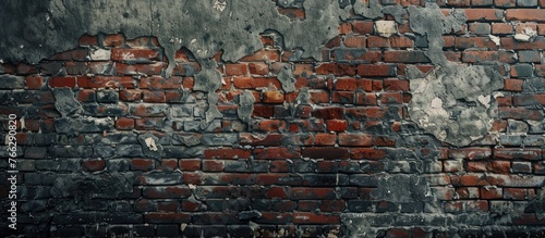Close up of a brick wall showing peeling paint, revealing layers of history and artistry in the brickwork pattern. Surrounding by grass and soil in the landscape