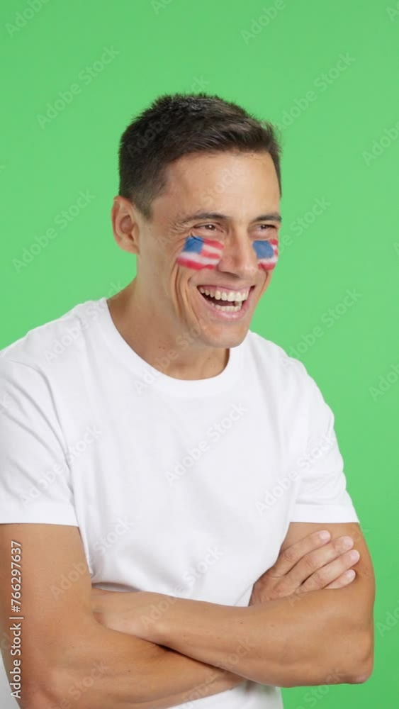 Happy man with USA flag painted on face looking away Happy man with USA flag painted on face looking away