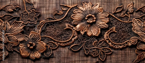 A beautiful brown wood carving of flowers and leaves adorns a hardwood surface, creating a stunning pattern in visual arts