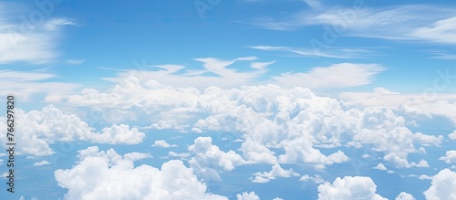 Numerous fluffy clouds drifting and floating across the vast blue sky creating a picturesque scene