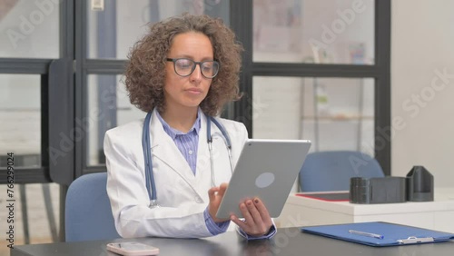 Hispanic Female Doctor Working on Digital Tablet in Hospital photo