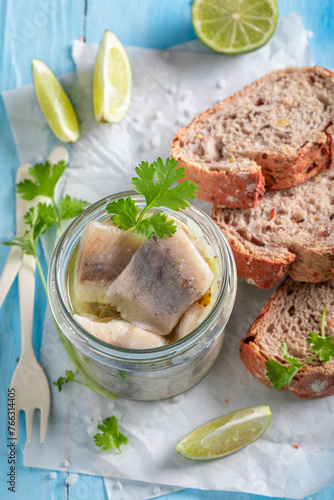 Healthy and tasty marinated herring with oil in jar.