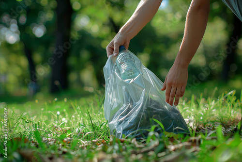 volunteer's hand gracefully picking up a discarded bottle and placing it into a garbage bag amidst a verdant park backdrop, photo photo