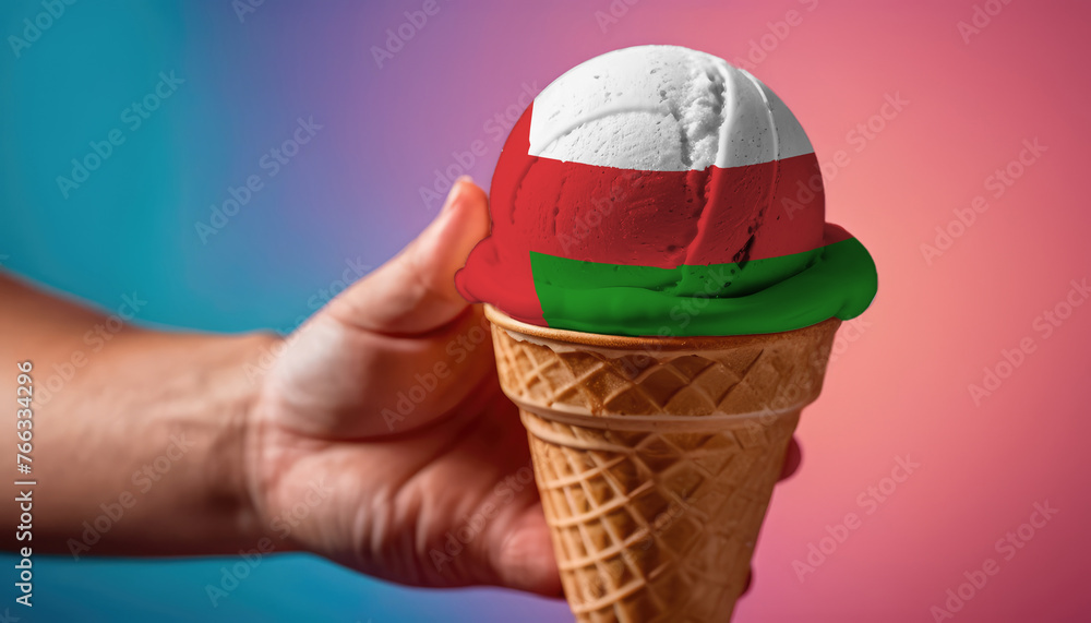 On a colorful background, a hand with ice cream in the form of the flag of Oman